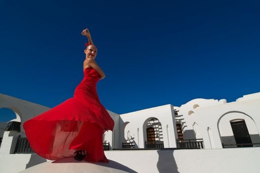 Attractive flamenco dancer wearing traditional red dress with flower in her hair