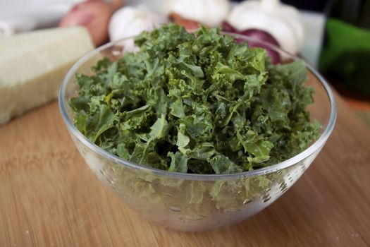 Fresh chopped Kale in clear glass bowl.