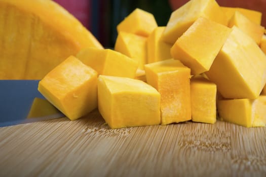 Cubed pumpkin on cutting board with knife