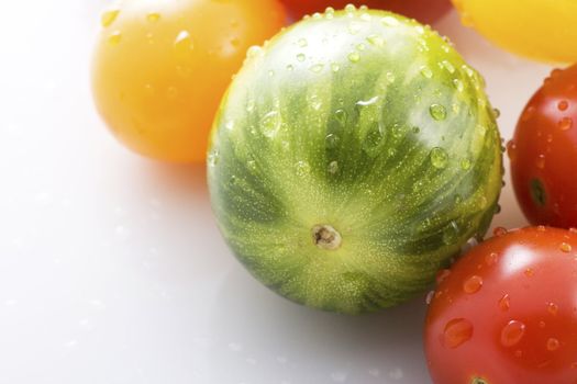 Wild green tomato covered in water drops