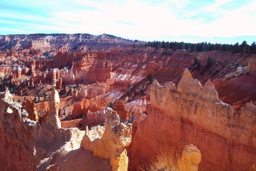 Bryce Canyon National Park is a national park located in southwestern Utah in the United States. Contained within the park is Bryce Canyon. Despite its name, this is not actually a canyon, but rather a giant natural amphitheater created by erosion along the eastern side of the Paunsaugunt Plateau. Bryce is distinctive due to its geological structures, called hoodoos, formed from wind, water, and ice erosion of the river and lakebed sedimentary rocks. The red, orange and white colors of the rocks provide spectacular views to visitors.