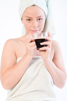 Studio portrait of a spa girl drinking coffee and making eye contact