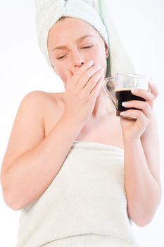 Studio portrait of a spa girl drinking coffee and yawning