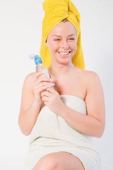 Studio portrait of a spa girl smiling with a bottle