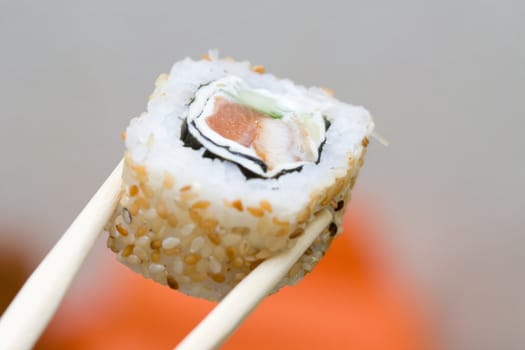 japanese roll with sesame taken with sticks