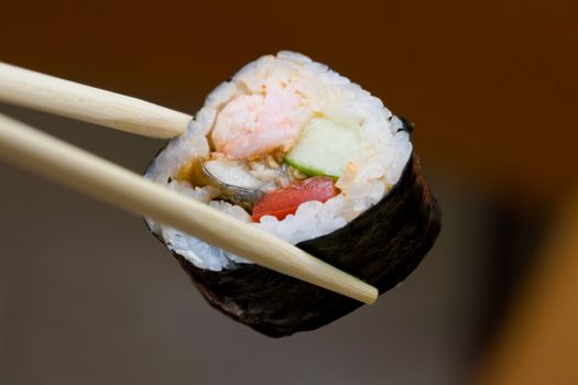 roll with shrimp and fish taken with chopsticks