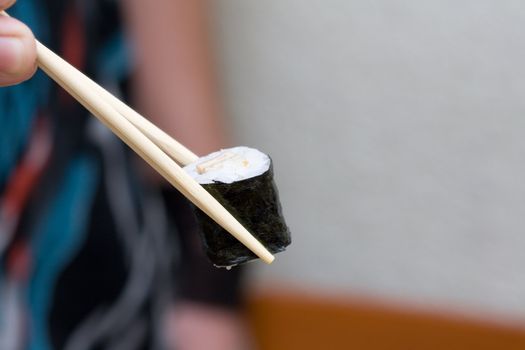 roll with egg taken with chopsticks