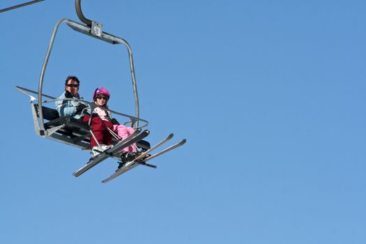 Two women high in the sky on the Ski lift.