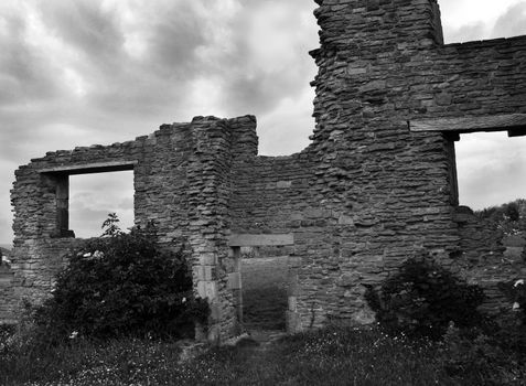 A ruined lodge under a moody, stormy sky