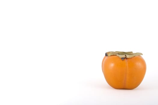 Single persimmon with copy space to the left.  Clipping path is included.