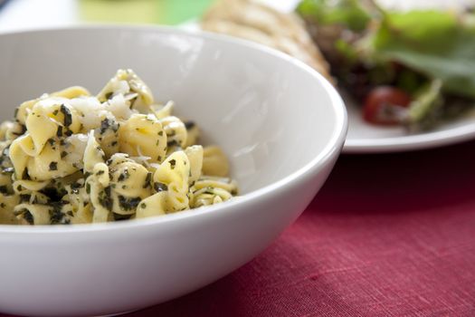 Delicious dinner of pesto perline pasta and salad.