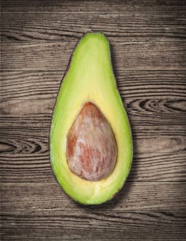 Avocado cut on wooden table, close up.