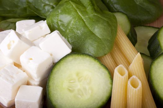 Feta cheese, cucumber, spinach and penne pasta ready for a pasta salad