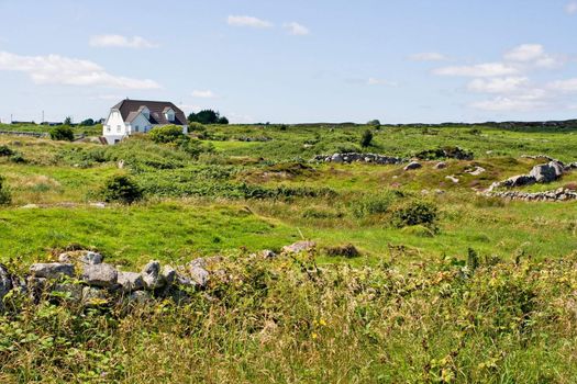 A single house in a green field. Location is Galway, Ireland.