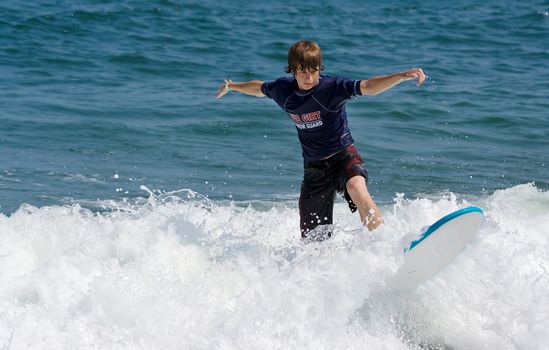 A teenage boy surfing in the ocean