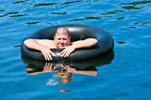 A man in water floating on an inner tube