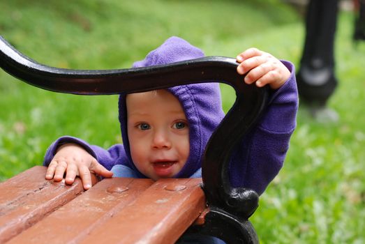 Happy toddler playing in the park in autumn