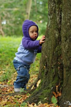 Happy toddler playing in the park in autumn