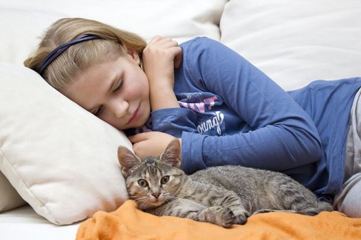 little girl and a kitten on the couch