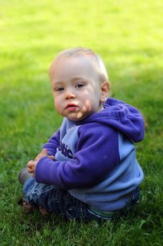 Cute toddler sitting in the grass