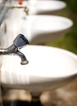 Metal water taps in a public beach