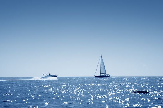 A small boat facing a motor boat on open sea