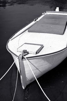 Old small wooden fishing boat , black and white toned photo