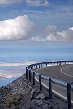 Empty highway on a mountain , you can see the sea bellow the mountain  at the horizon