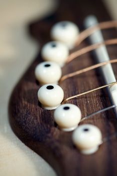 An acoustic guitar close up , shallow DOF photo