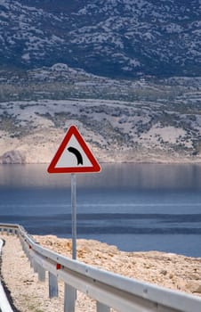 Warning sign on the road near the sea