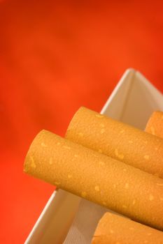 Macro of pack of cigarettes on orange background