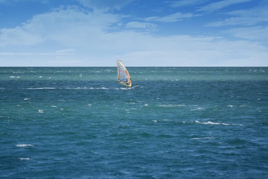 Windsurfer sailing on open sea on a windy day