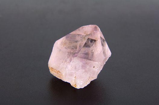 large amethyst crystal on a gray background