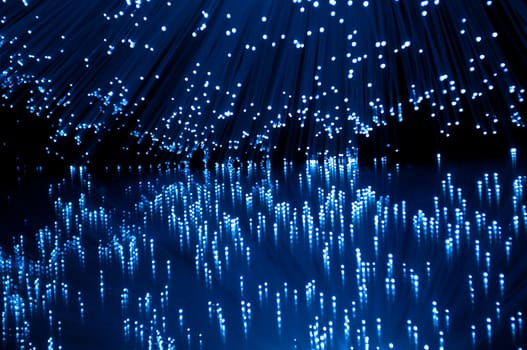 Vibrant blue fibre optic light strands reflecting into foreground.