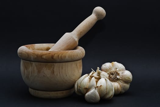 Garlic with mortar and pestle isolated on a black background.