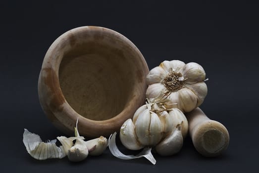 Garlic with mortar and pestle isolated on a black background.