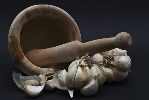 Garlic with mortar and pestle isolated on a black background.