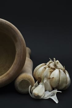 Garlic with mortar and pestle isolated on a black background.