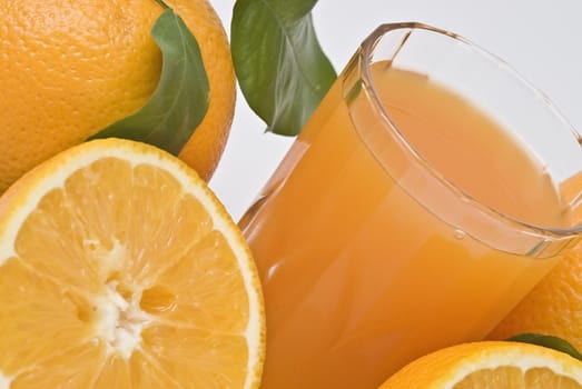 Spanish oranges from Valencia with leaves and its juice isolated on a white background.