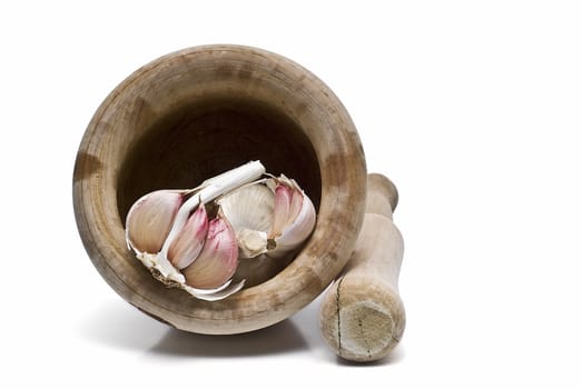 Mortar and pestle with some garlic isolated on a white background.