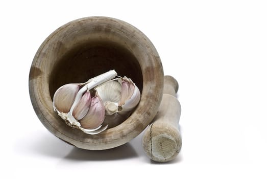 Mortar and pestle with some garlic isolated on a white background.