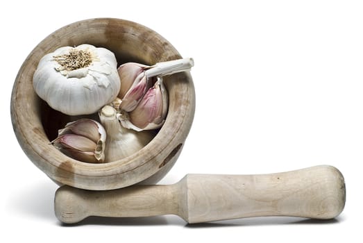 Mortar and pestle with some garlic isolated on a white background.