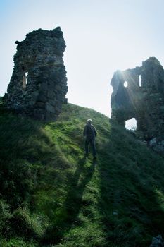 old man walking on top of a hill, ruins of old castle, photo taken in East Slovakia