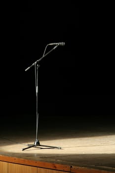 microphone on wooden stage, black background