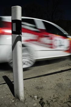 red and white rally car in motion,