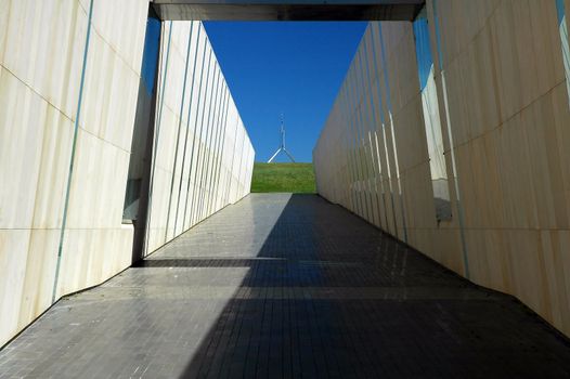 modern construction in Canberra, australian flag on Canberra Parliament House in background