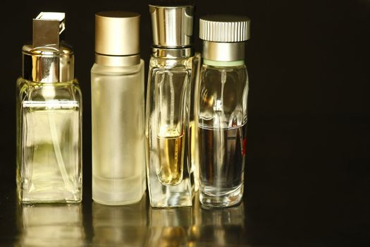 Perfume bottles with reflection in balck background.