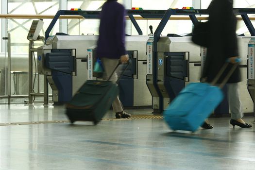 Travel entrance ticketing machine with traveller moving in.