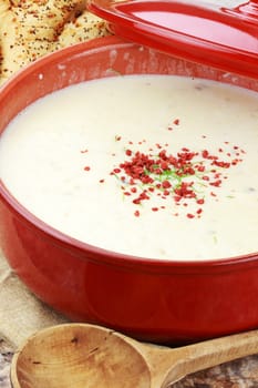 Homemade potato soup garnished with bacon bits and chives and served with Italian herb bread.