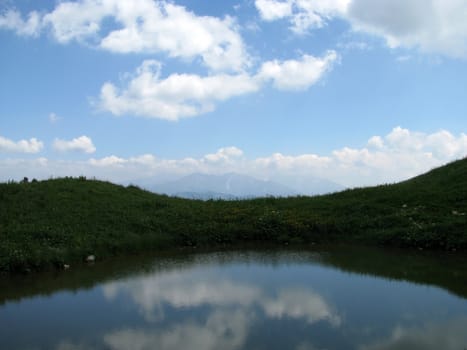 Mountains; rocks; a relief; a landscape; a hill; a panorama; Caucasus; top; lake; water; reflection; a slope